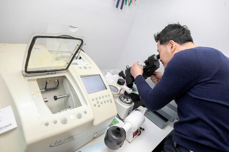 Sopheak Tang checking eyewear with optical equipment